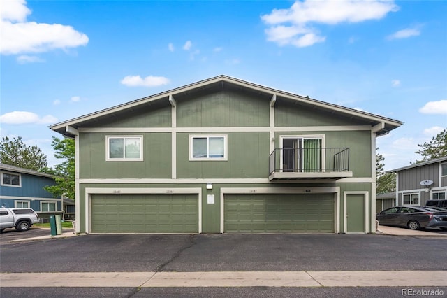 1216 S Uvalda St, Aurora, CO 80012 - view of property featuring a garage, asphalt driveway, and a balcony