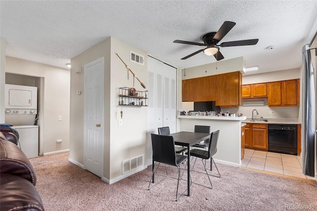 1216 S Uvalda St, Aurora, CO 80012 - kitchen with black dishwasher, stacked washer and clothes dryer, brown cabinetry, a sink, and light colored carpet