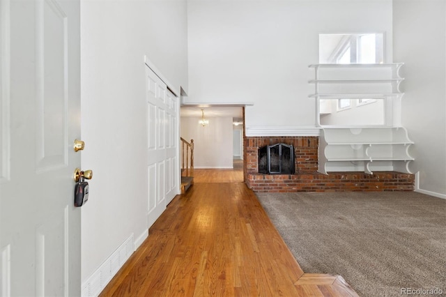 unfurnished living room with hardwood / wood-style floors and a brick fireplace