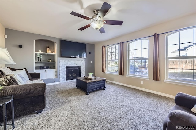 9990 Jasper St, Commerce City, CO 80022 - carpeted living room featuring built in features, plenty of natural light, a ceiling fan, and baseboards