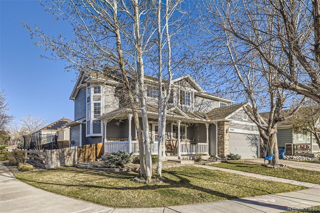 9990 Jasper St, Commerce City, CO 80022 - traditional-style home with covered porch, an attached garage, concrete driveway, and a front lawn