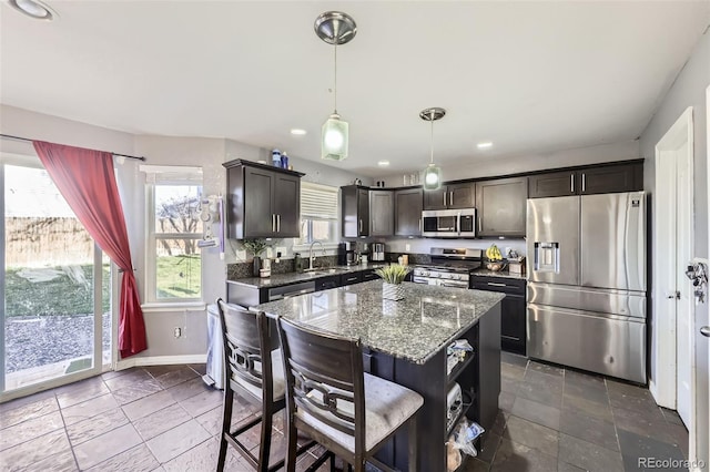 9990 Jasper St, Commerce City, CO 80022 - kitchen with stainless steel appliances, a sink, recessed lighting, baseboards, and dark stone counters