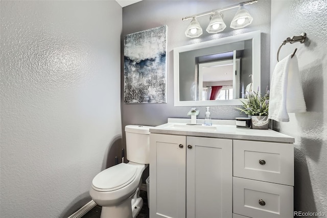 9990 Jasper St, Commerce City, CO 80022 - bathroom with vanity, toilet, and a textured wall