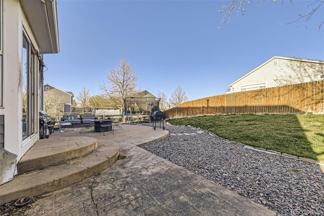9990 Jasper St, Commerce City, CO 80022 - fenced backyard featuring a patio and a trampoline