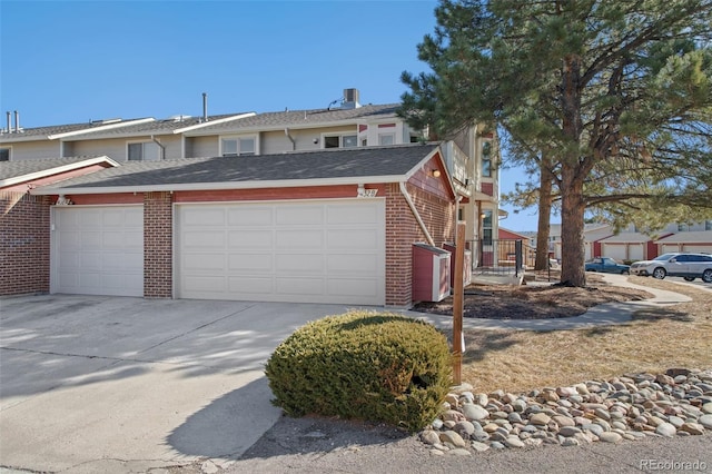 432 W Rockrimmon Blvd Unit B, Colorado Springs, CO 80919 - view of front of home featuring a garage, brick siding, concrete driveway, and a shingled roof
