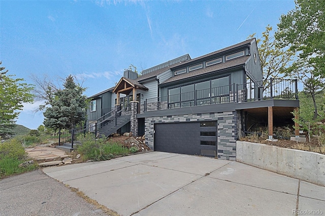 8036 Firethorn Dr, Loveland, CO 80538 - view of front facade featuring stairs, driveway, a garage, and stone siding