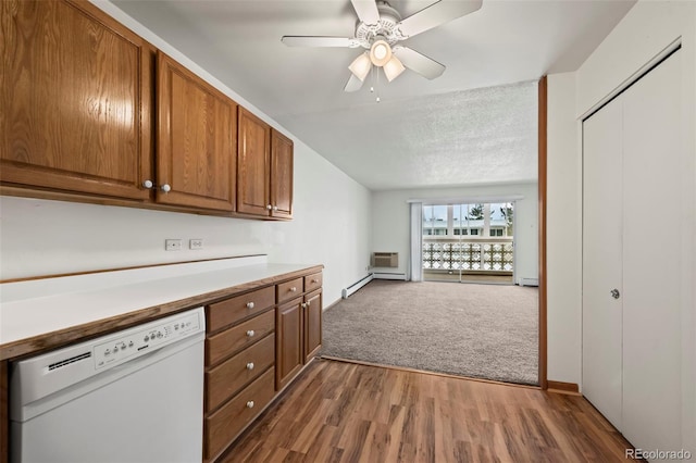 kitchen with ceiling fan, a baseboard heating unit, white dishwasher, a textured ceiling, and dark carpet