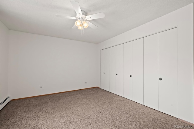 unfurnished bedroom featuring baseboard heating, a closet, ceiling fan, and carpet