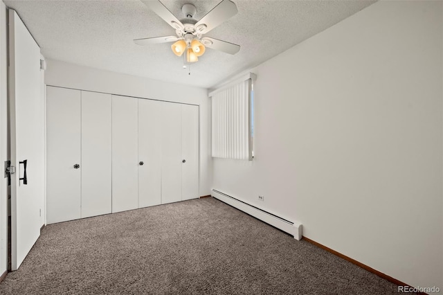 unfurnished bedroom with a textured ceiling, baseboard heating, carpet floors, a closet, and ceiling fan