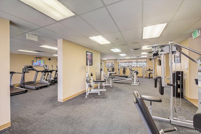 exercise room featuring carpet flooring and a paneled ceiling