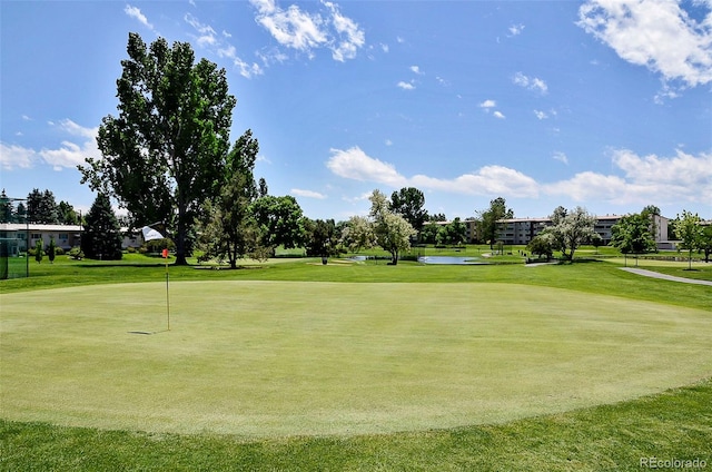 view of home's community featuring view of golf course and a yard