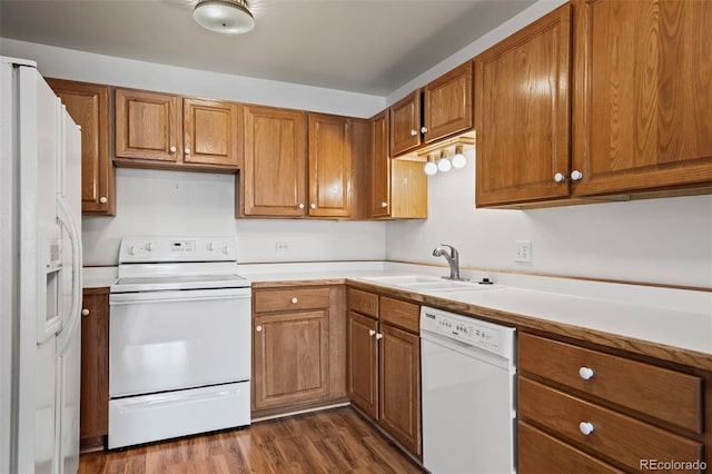 9300 E Center Ave Unit 2B, Denver, CO 80247 - kitchen with white appliances, a sink, brown cabinetry, light countertops, and dark wood-style flooring