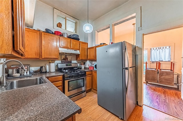 939 Conejos St, Colorado Springs, CO 80903 - kitchen with appliances with stainless steel finishes, dark countertops, under cabinet range hood, brown cabinetry, and a high ceiling
