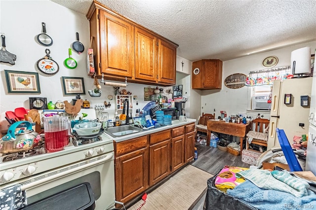 939 Conejos St, Colorado Springs, CO 80903 - kitchen featuring white appliances, a textured ceiling, brown cabinetry, light countertops, and wood finished floors