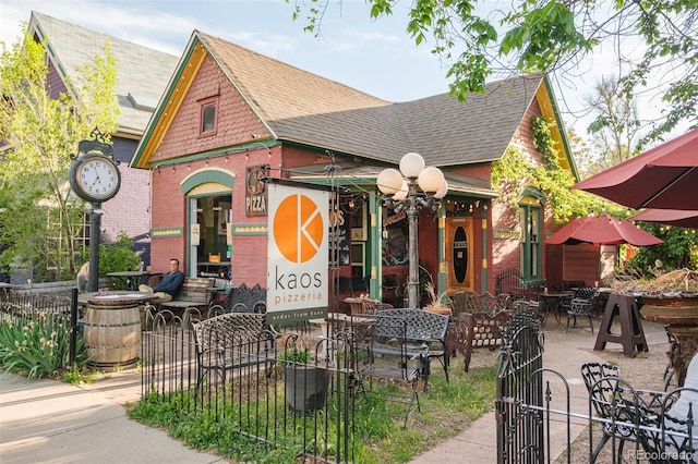 1188 S Sherman St, Denver, CO 80210 - view of front facade featuring a shingled roof, a gate, and brick siding