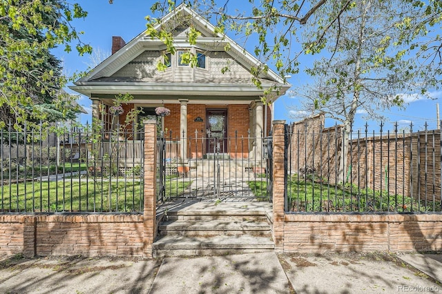 view of front facade with a porch, a fenced front yard, a chimney, a gate, and brick siding