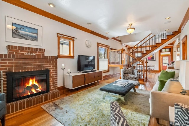 living room with stairway, wood finished floors, a brick fireplace, recessed lighting, and baseboards