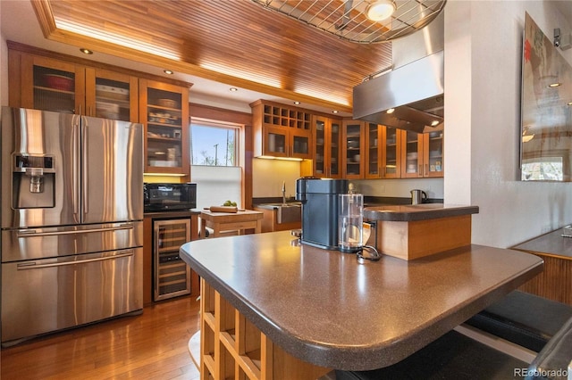 kitchen with stainless steel fridge with ice dispenser, wine cooler, black microwave, dark countertops, and a peninsula