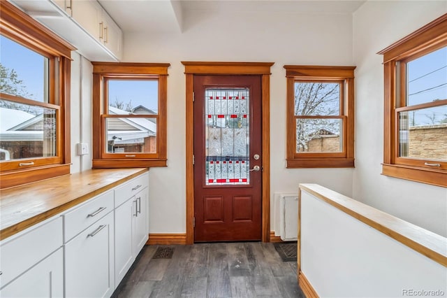 entryway with dark wood-style floors and baseboards