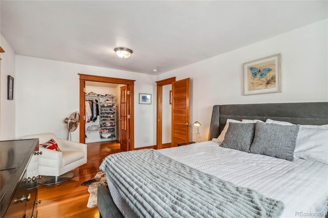 bedroom featuring wood finished floors, a spacious closet, and a closet