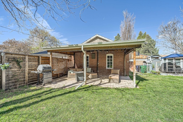 rear view of house featuring outdoor lounge area, a patio area, and brick siding