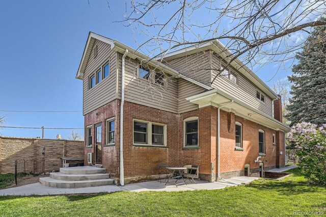 back of house featuring brick siding and a patio