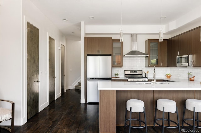 1932 W 32nd Ave, Denver, CO 80211 - kitchen with wall chimney exhaust hood, stainless steel appliances, backsplash, light countertops, and recessed lighting