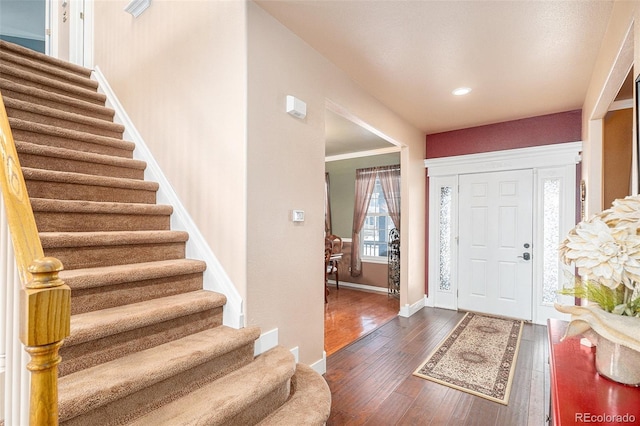 entrance foyer featuring dark hardwood / wood-style flooring and crown molding