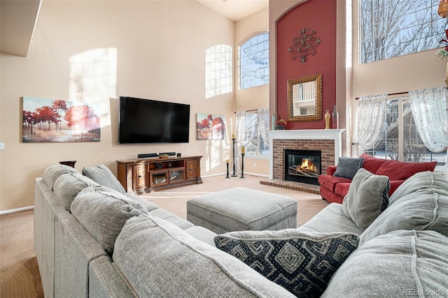 carpeted living room with a high ceiling and a brick fireplace