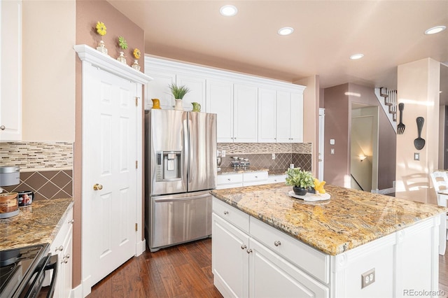 kitchen with a kitchen island, white cabinets, and appliances with stainless steel finishes