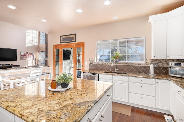 kitchen with sink, white cabinetry, dishwasher, and light stone counters