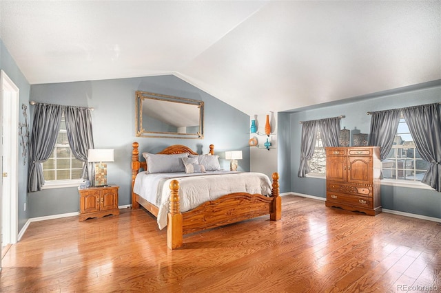 bedroom with vaulted ceiling and hardwood / wood-style floors