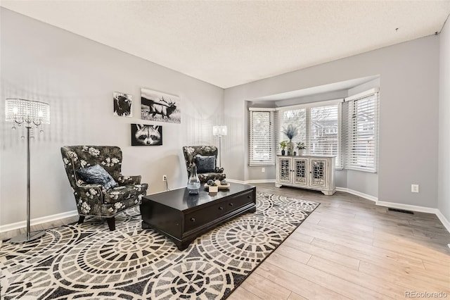 living area featuring wood finished floors, baseboards, and a chandelier