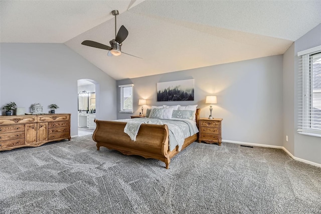 bedroom featuring vaulted ceiling, carpet flooring, arched walkways, ceiling fan, and baseboards