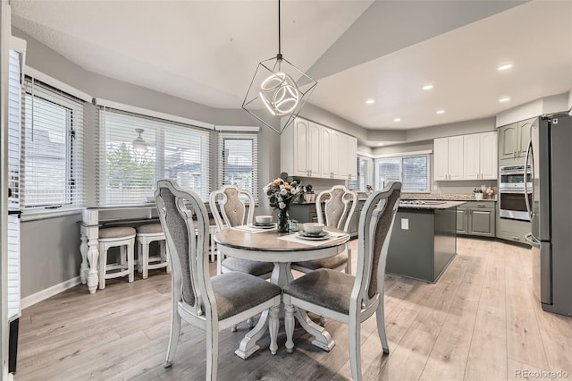 dining space featuring light wood-style flooring, lofted ceiling, baseboards, and recessed lighting
