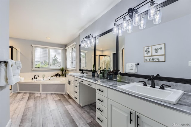 full bath featuring a garden tub, wood finished floors, double vanity, and recessed lighting