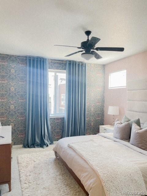 bedroom with ceiling fan and a textured ceiling