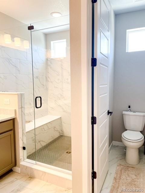 bathroom with toilet, an enclosed shower, plenty of natural light, and vanity