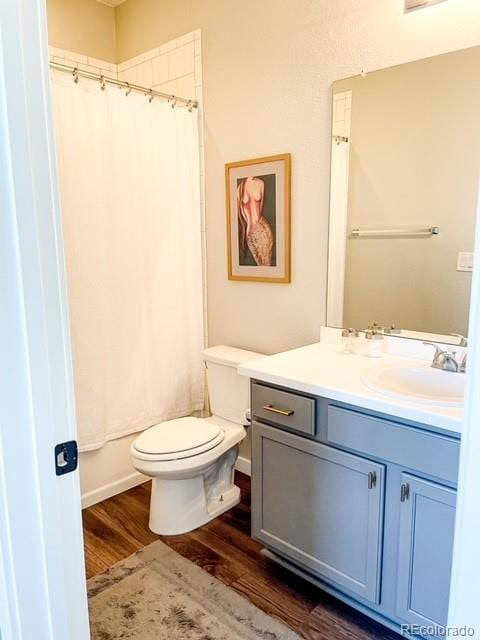 full bathroom with vanity, hardwood / wood-style floors, toilet, and shower / bath combo