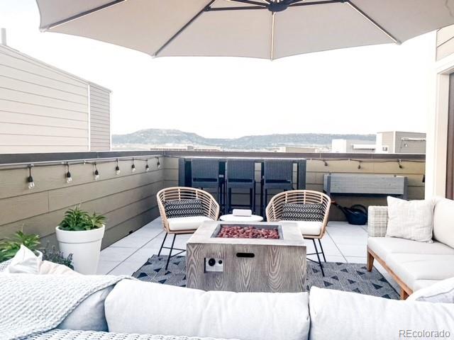 view of patio / terrace with a mountain view and an outdoor living space with a fire pit