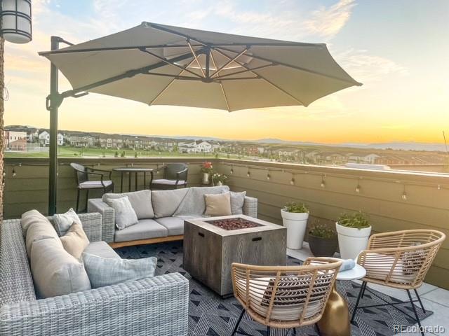 balcony at dusk featuring an outdoor living space with a fire pit