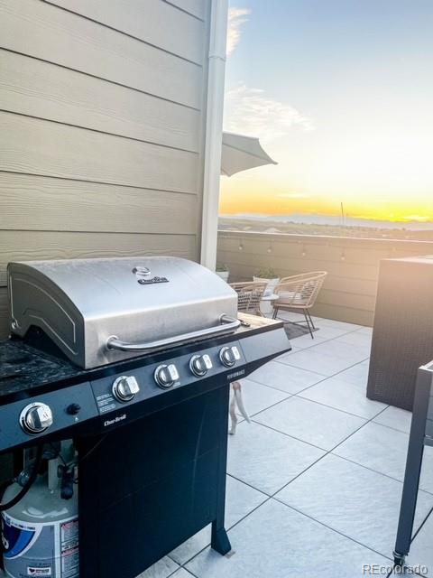 patio terrace at dusk featuring a grill