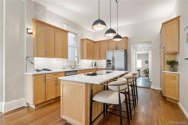 2355 N Emerson St, Denver, CO 80205 - kitchen featuring appliances with stainless steel finishes, light brown cabinetry, hardwood / wood-style floors, and backsplash