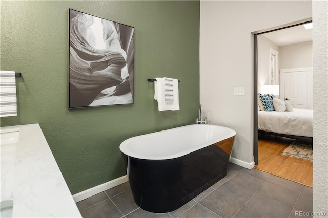 2355 N Emerson St, Denver, CO 80205 - ensuite bathroom featuring tile patterned floors, a soaking tub, and baseboards
