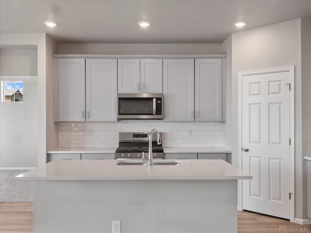 17557 E 89th Way, Commerce City, CO 80022 - kitchen with appliances with stainless steel finishes, light countertops, light wood-style flooring, tasteful backsplash, and recessed lighting
