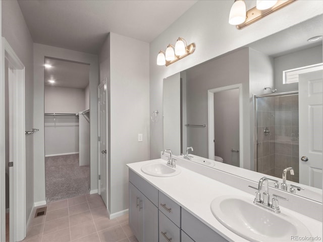 17557 E 89th Way, Commerce City, CO 80022 - full bathroom featuring a shower stall, double vanity, a spacious closet, and tile patterned floors