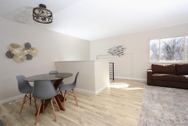 dining area with wood finished floors, visible vents, and baseboards