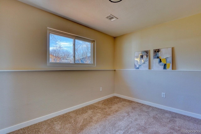 empty room with visible vents, baseboards, and carpet floors