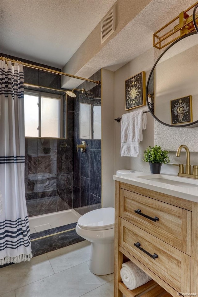 full bathroom featuring visible vents, toilet, a textured ceiling, tiled shower, and vanity