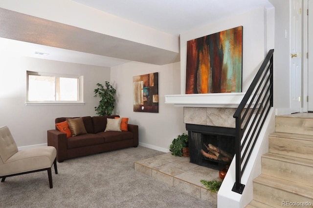 living room featuring stairway, carpet floors, baseboards, and a fireplace